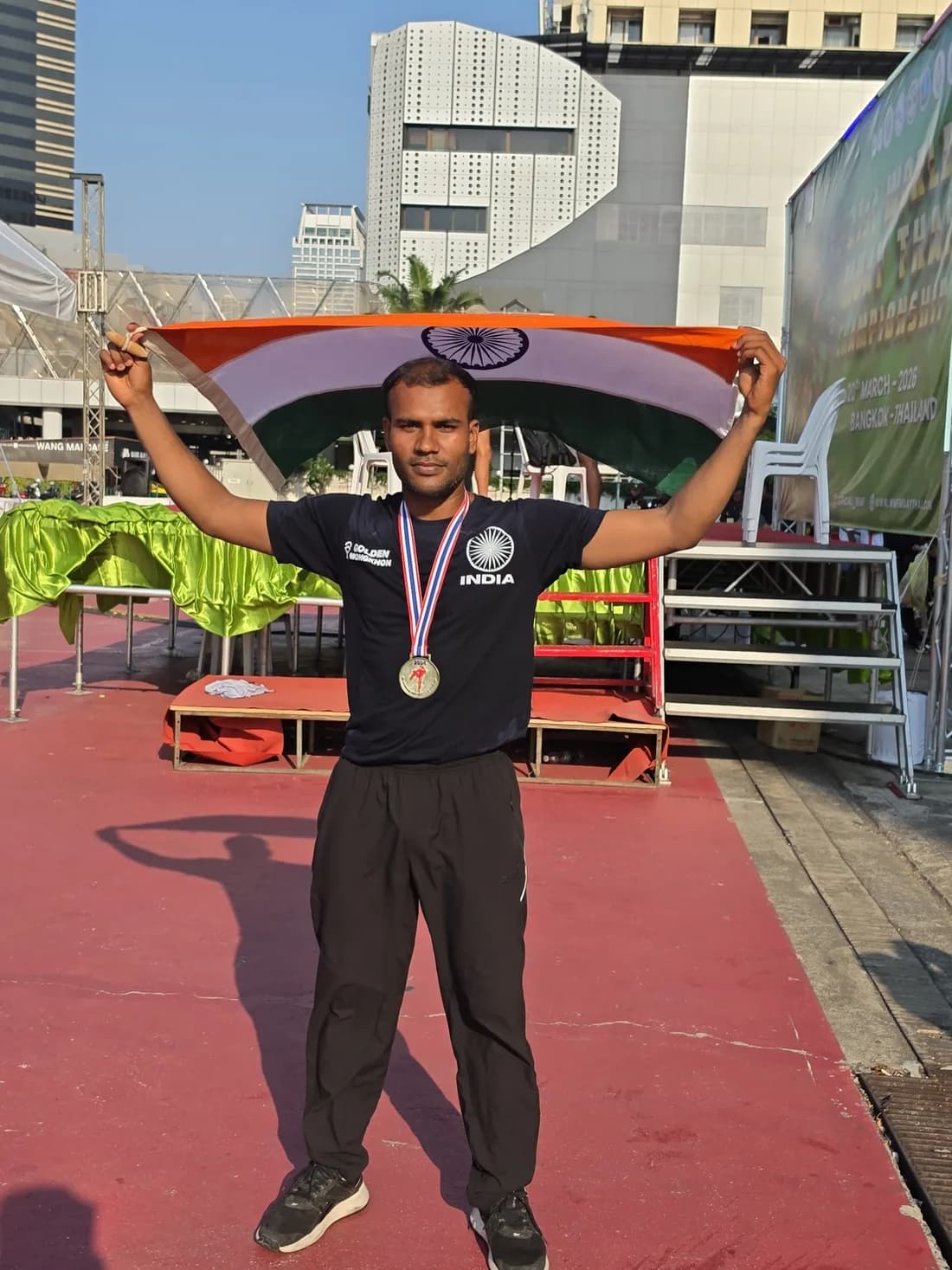 Bengaluru MMA fighter with the Indian flag and a championship medal